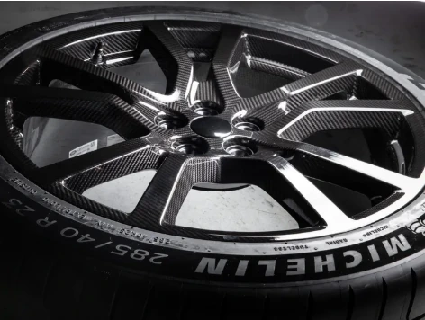 Detail view of dark carbon-fibre performance wheel and Michelin tyre
