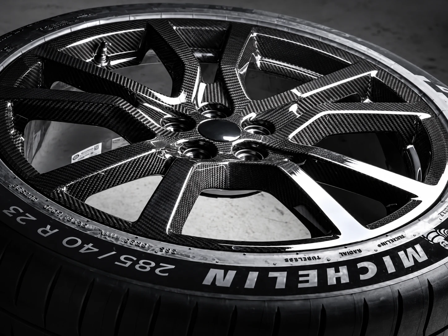 High-resolution close-up of a carbon-fibre performance wheel with Michelin tyre lettering