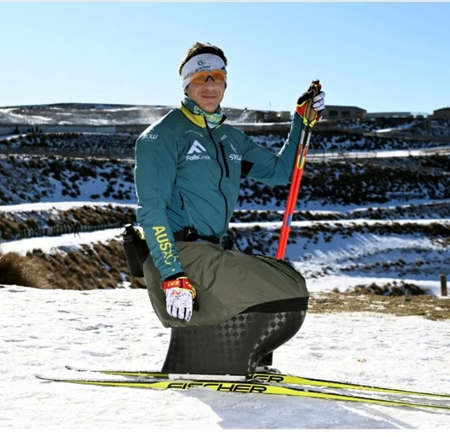 Athlete pictured with an adaptive Nordic skiing setup in a snowy landscape.